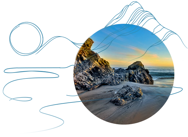 A California beach at sunset showing rock formations on the sand.